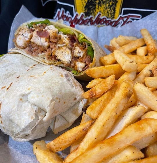 Turkey, guacamole, bacon, provolone cheese, lettuce, tomato in a flour tortilla.