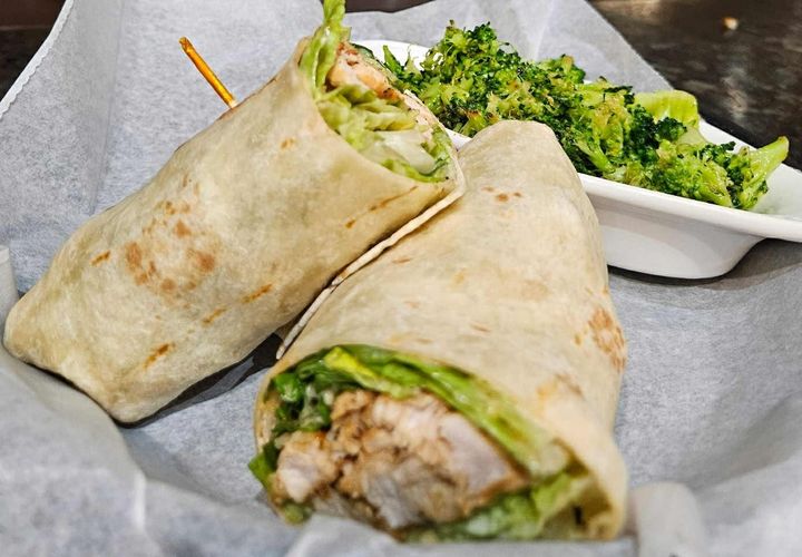 Experience the classic flavors of a Caesar salad, perfectly portable! Our Chicken Caesar Wrap features tender grilled chicken, crisp romaine lettuce, savory Parmesan cheese, and a creamy, zesty Caesar dressing, all snugly rolled in a soft flour tortilla. It's a fresh, satisfying, and flavor-packed meal that's easy to enjoy on the go!