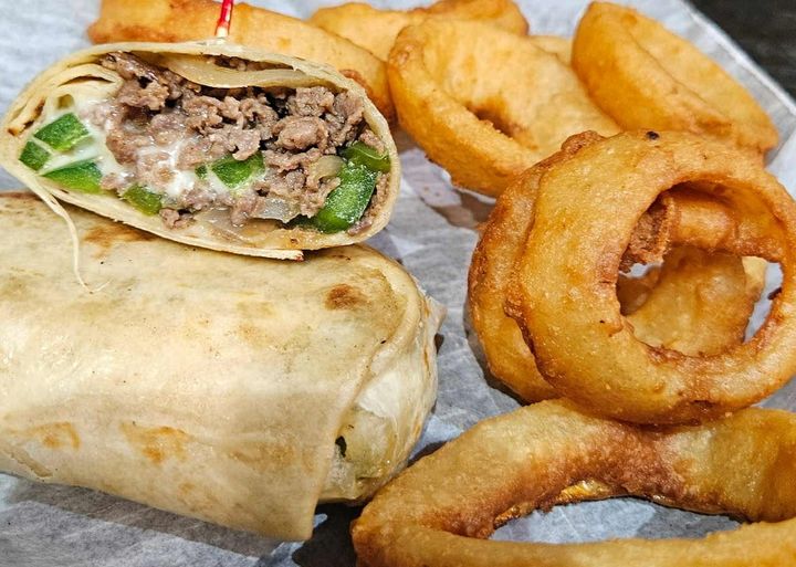 Our Philly Cheese Steak Wrap is bursting with flavor! We take juicy, seasoned steak, sauté it with tender onions and bell peppers, then load it into a soft tortilla with a generous helping of melty white american (or your cheese of choice!). It's a quick, cheesy, and utterly satisfying meal perfect for any time of day.