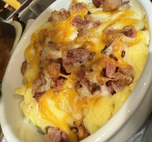 Our velvety homemade mashed potatoes are taken to the next level! We top them generously with crunchy Applewood bacon and a blend of savory cheddar jack cheese, creating a side dish that's impossible to resist!