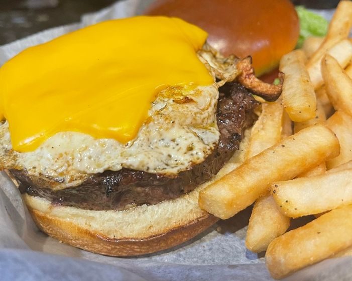 Fuel up with our generous 1/2lb Angus Steak Burger, topped with a fried egg, a pile of crispy Applewood bacon, and your preferred cheese. Served on a brioche roll, it's a satisfying masterpiece that comes with one regular side item.