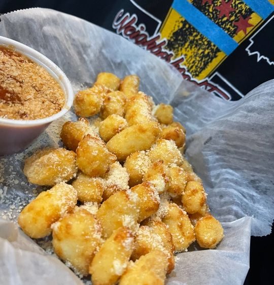 Experience cheesy bliss with our mini white cheddar cheese curds, crispy on the outside and wonderfully melty within. Served alongside a vibrant marinara dipping sauce and a generous finish of grated Parmesan cheese